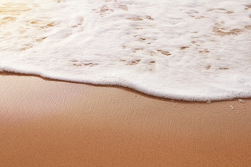 Fototapeta na wymiar Background. White wave on the sand. Toned photo.