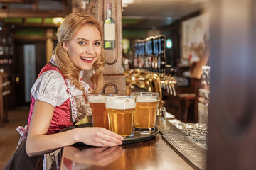 Happy young waitress carrying beverage