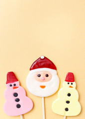 Lollipops new year sweets. Candy christmas snowman, top view flat lay on yellow background. Sweet sucker, lollipop snowman, candy, isolated minimal concept above decoration, new year food background