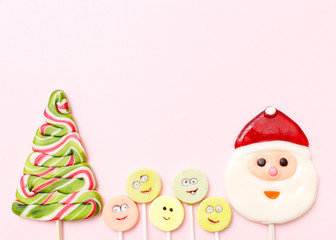 Lollipops new year sweets. Candy christmas tree, top view flat lay on pink background. Sweet sucker, lollipop snowman, candy, isolated minimal concept above decoration, new year food background