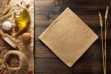 ears of wheat and bakery ingredients on wood