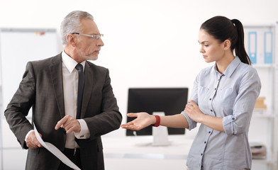 Serious brunette stretching her arm to colleague