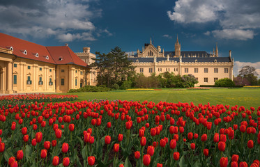 Obraz premium Beautiful view of Lednice Castle with storm clouds and blooming red tulips.Lednice palace is one of the most impressive and visited historical sights in the Czech Republic. South Moravia attractions