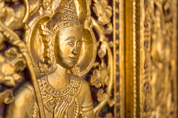 Fototapeta na wymiar Beautiful golden carving on the door of Wat Sensoukharam temple in Luang Prabang, Laos