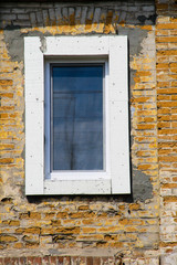 Modern plastic window on old brick wall