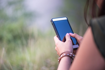 Asian woman holding smart phone.