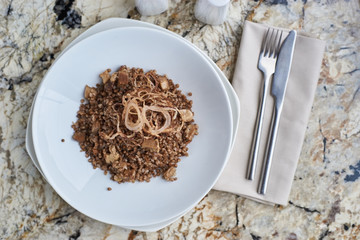 Buckwheat with porcini mushrooms served on white plate on marble table