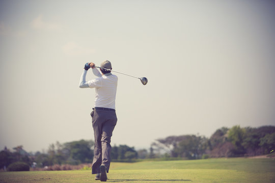 Golfers hit sweeping golf course in the summer vintage color