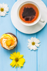 Still life with cup of tea and cake on the wooden background