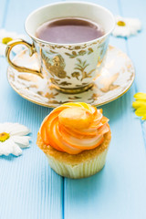 Still life with cup of tea and cake on the wooden background