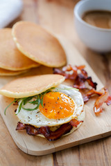 pancake with fried egg and bacon sandwich for breakfast