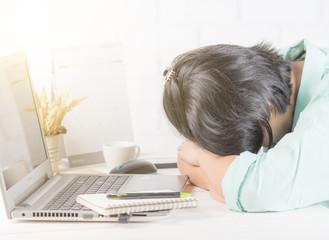 Naklejka premium Tired businesswoman sleeping on the desk in front of laptop