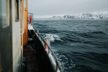 Fishing ship is swimming at sea at winter