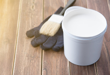 Paint bucket with paint brush on the old wooden background with copy space