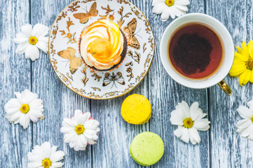 Still life with cup of tea and cake on the wooden background