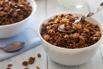 Bowl of granola with raisins and spoon