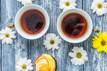 Still life with cup of tea and cake on the wooden background