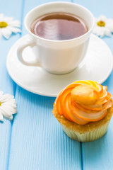 Still life with cup of tea and cake on the wooden background