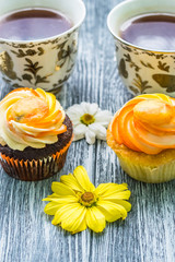 Still life with cup of tea and cake on the wooden background