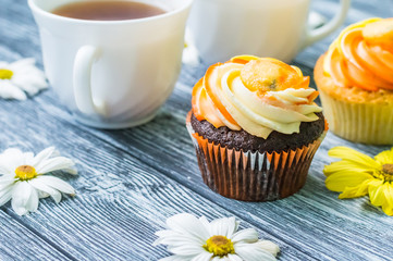 Still life with cup of tea and cake on the wooden background