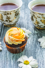 Still life with cup of tea and cake on the wooden background