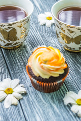 Still life with cup of tea and cake on the wooden background