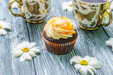 Still life with cup of tea and cake on the wooden background