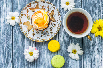 Still life with cup of tea and cake on the wooden background