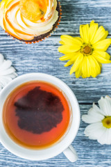Still life with cup of tea and cake on the wooden background