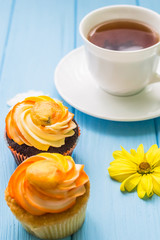 Still life with cup of tea and cake on the wooden background