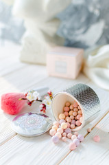 Powder for the face in balls on a light wooden table
