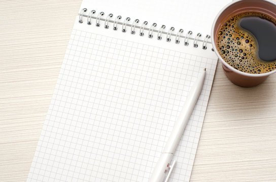 Notepad for text. White pen, Cup of coffee