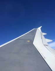 sunlit jet wing in flight in clear blue sky