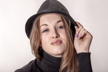 Portrait of a beautiful girl with long hair in a hat

