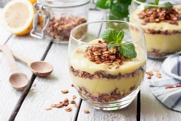 Gordijnen Gezond dessert in een glas met citroenroom en granola © yuliiaholovchenko