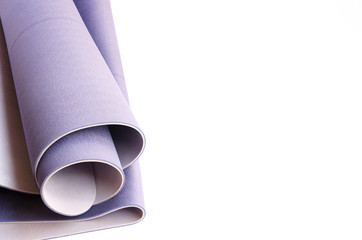 Rolled lilac exercise mat for yoga,pilates or fitness on white isolated background with copy space.