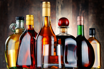Glass and bottles of assorted alcoholic beverages