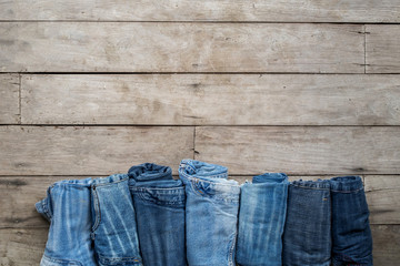 Top view, Roll and Jeans stacked on a wooden background.