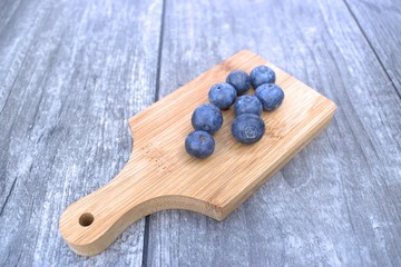 Fresh blueberries on bamboo cutting board