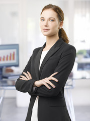 Confident professional woman. Shot of a smiling young businesswoman standing in the office with arms crossed. 