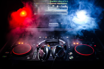 DJ Spinning, Mixing, and Scratching in a Night Club, Hands of dj tweak various track controls on...