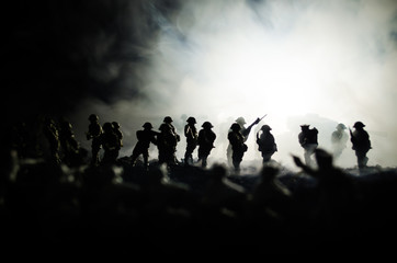 Fototapeta na wymiar War Concept. Military silhouettes fighting scene on war fog sky background, World War Soldiers Silhouettes Below Cloudy Skyline At night. Attack scene. Armored vehicles