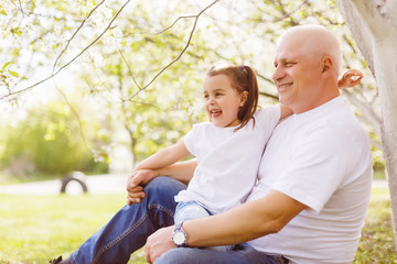 Fototapeta premium grandfather and his little granddaughter together in garden