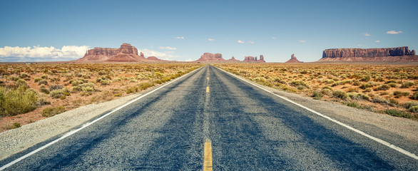Desert highway leading into Monument Valley - obrazy, fototapety, plakaty