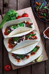 Mexican fajitas with beef and grilled vegetables paprika, red onion, tomato. Top view