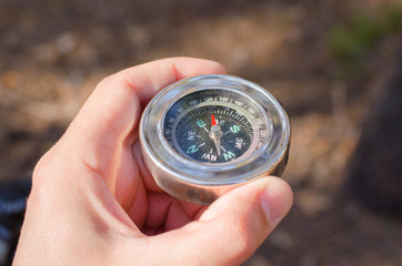 Male hand holding a compass