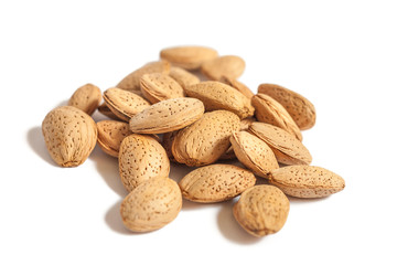 A lot of almond nuts in the shell isolated on white background, selective focus