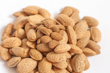 Almonds heart on isolated on white background, almonds in shells in the shape of a heart with some purified nuts on the top, happy valentines day, simplicity