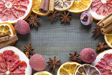 Lychee fruits with citrus slices and star anise on wooden background