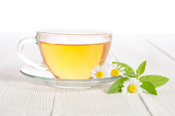 Cup of medicinal chamomile tea  on the wooden table